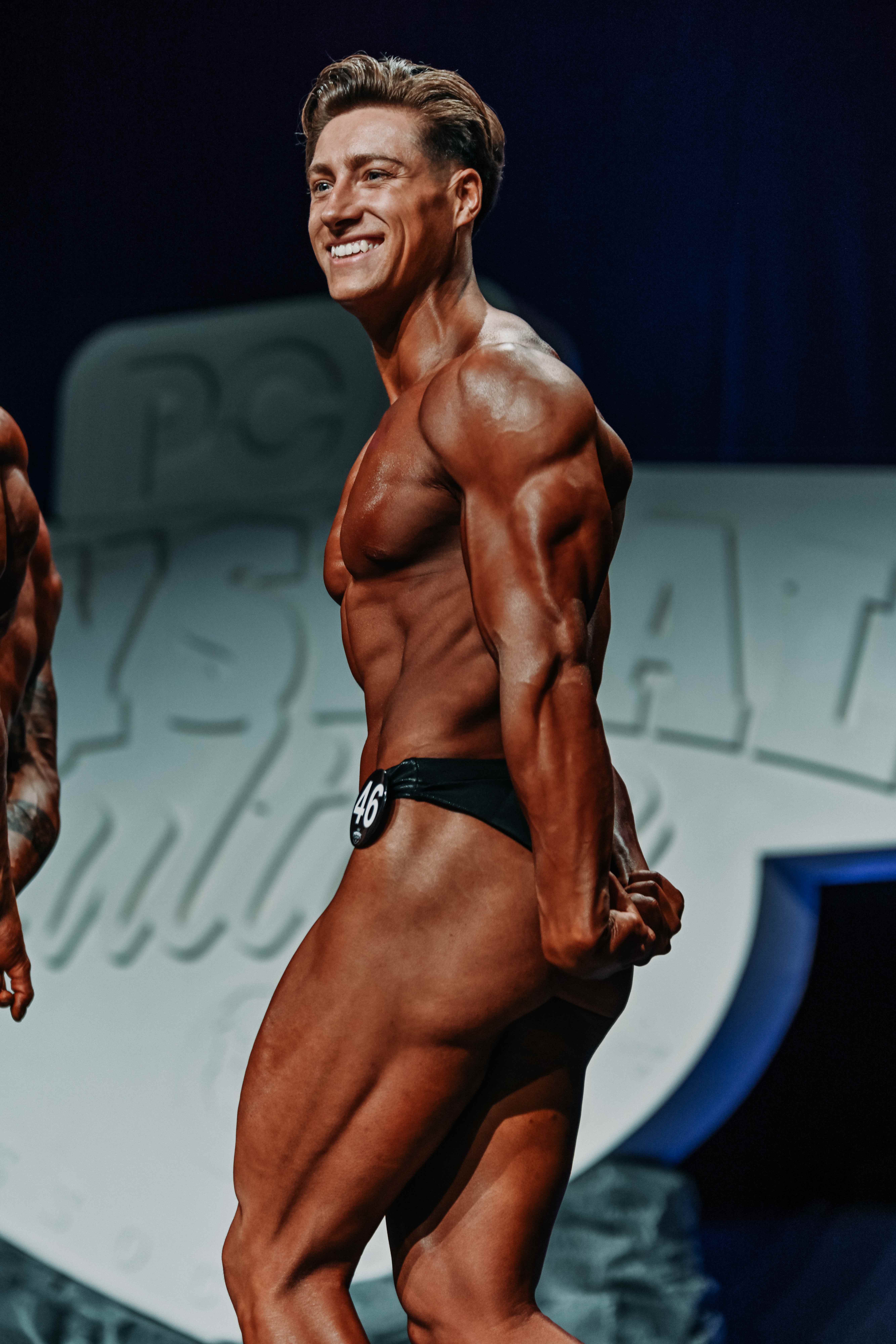 Side chest pose at physique competition